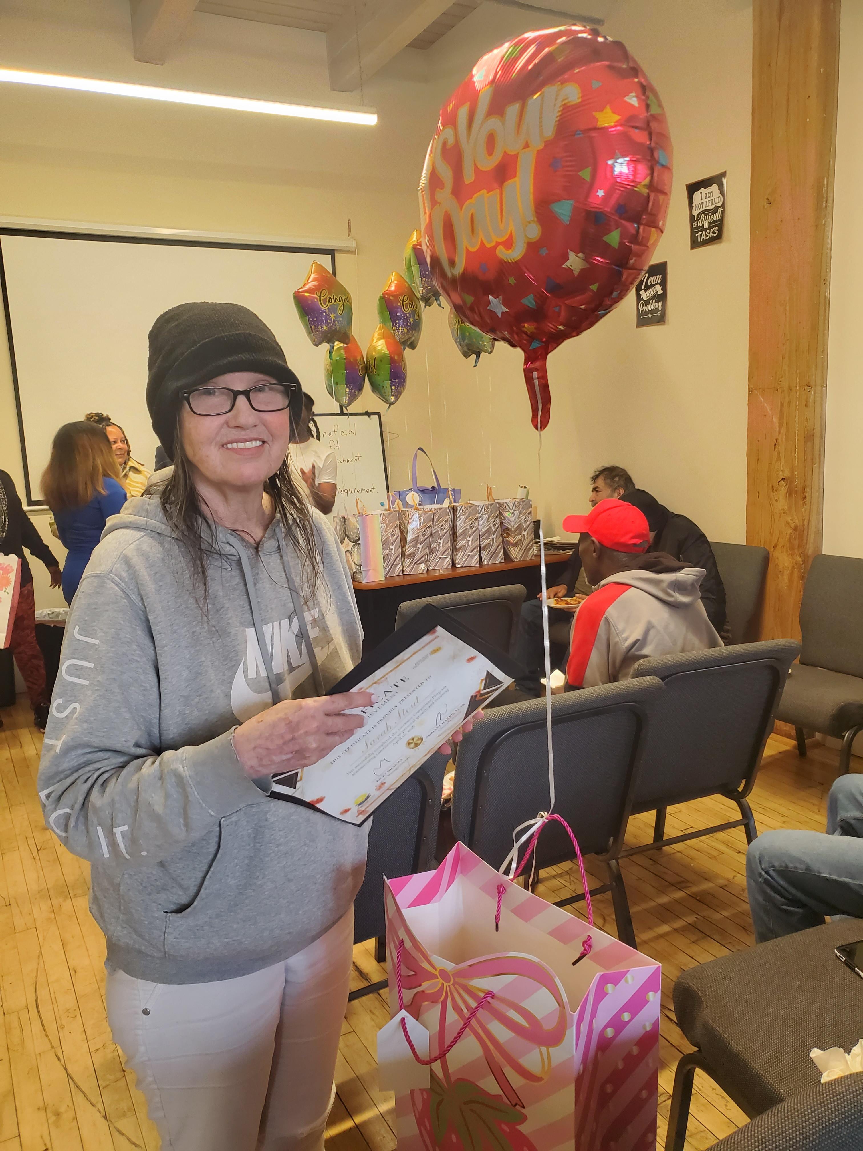 Graduate with balloon and certificate
